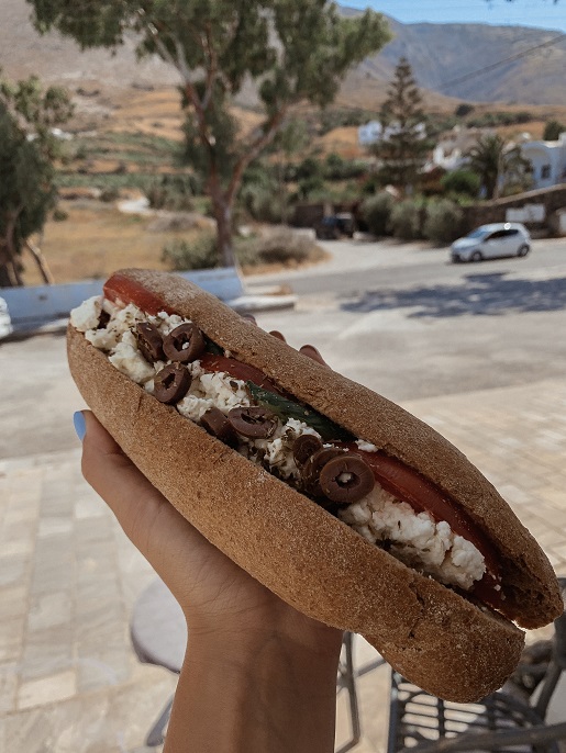 Traditional bakery snack - a sandwich with feta cheese, tomato and olives