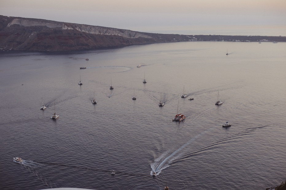 Yachts coming back to the port after the sunset in the caldera